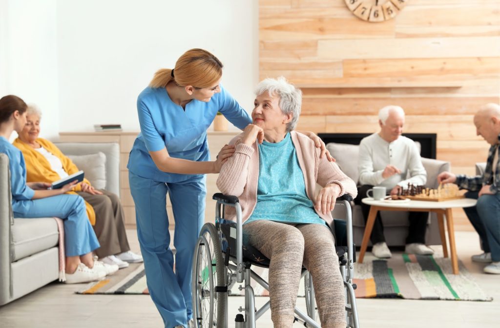 Elder woman accompanied by nurse in senior home community.