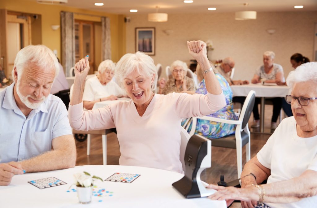 Seniors sitting at table in dinning room playing bingo